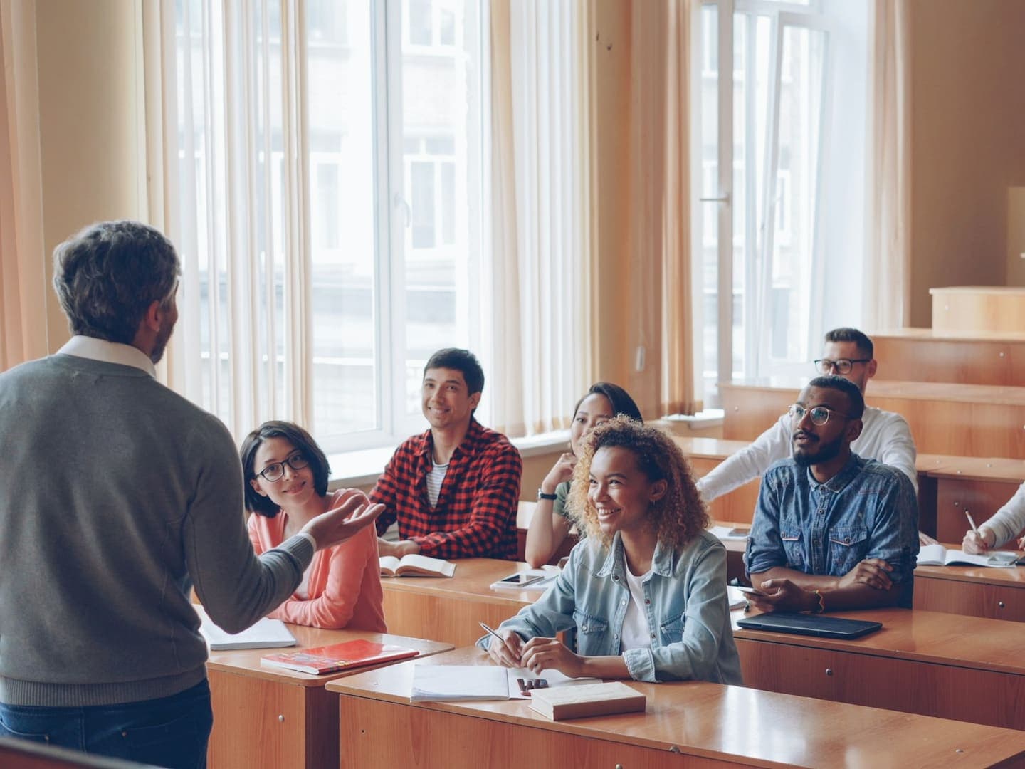 Un enseignant échange avec ses étudiants dans un amphithéâtre en bois clair
