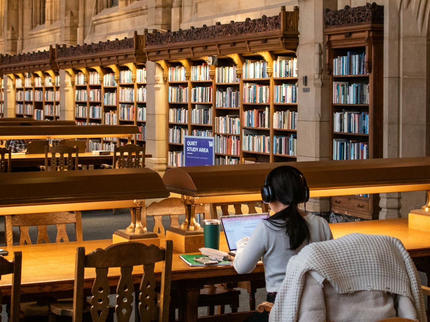 Une étudiante travaille sur son ordinateur portable dans une bibliothèque